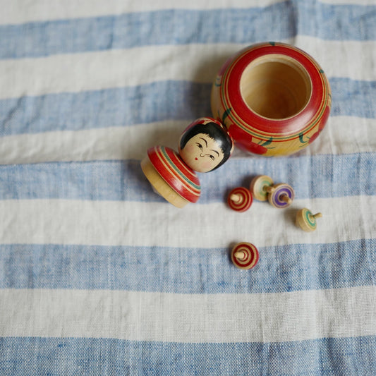 Kokeshi with Five Miniature Spinning Tops, Seller-Attributed to Eiji Aida – source photo 1